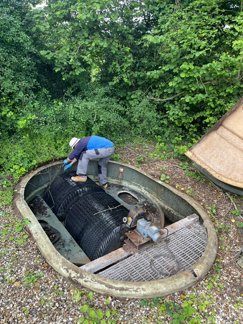 Engineer servicing a sewage treatment plant during routine maintenance